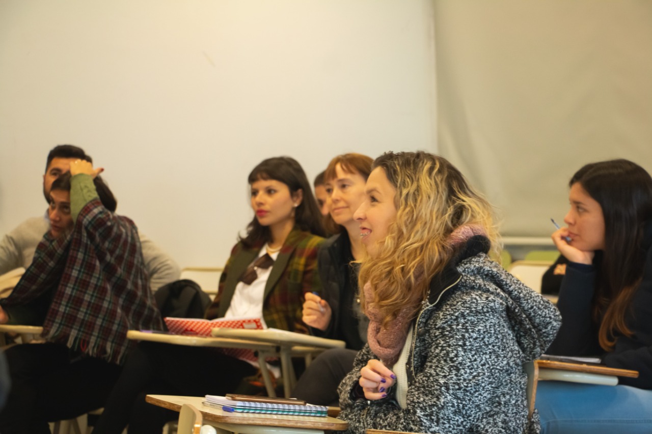 Personas sentadas en bancos de un aula en la presentación del programa Soy Tu Tienda.