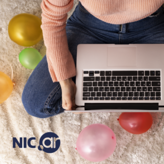 persona que tiene una laptop sobre sus piernas y globos alrededor
